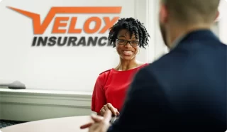 Velox Insurance agent talking with a customer.
